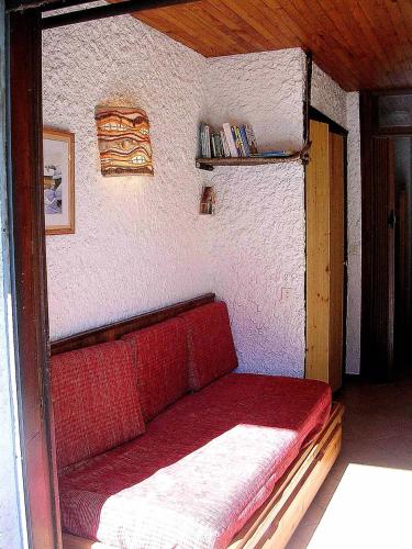 - un canapé rouge dans une chambre avec un mur dans l'établissement Résidence Les PrimevÈres - Studio pour 4 Personnes MAE-3339, à Champagny-en-Vanoise