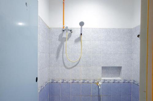 een badkamer met een douche met blauwe tegels bij J&B Rooms Tomang Jakarta Mitra RedDoorz in Jakarta