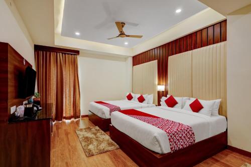 a hotel room with two beds and a television at OYO SAI GRAND LUXURY ROOMS in Tirupati