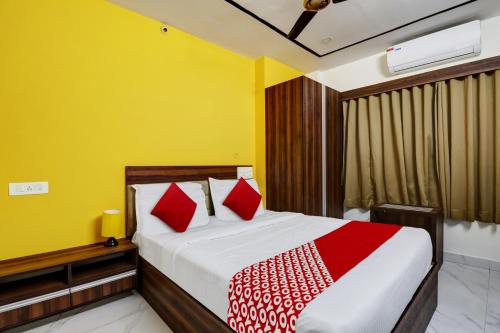 1 dormitorio con 1 cama con almohadas rojas y blancas en OYO Hotel Golden Residency, en Bangalore