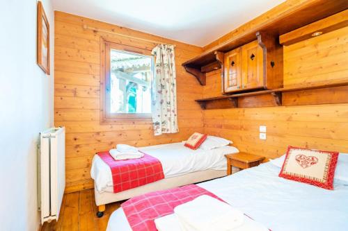 2 camas en una habitación con paredes de madera en Résidence Les Alpages de Reberty - maeva Home - Appartement 3 pièces 6 per 144 en Les Menuires