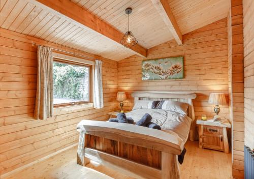 a bedroom with a bed in a wooden room at Riverview Lodge in Llanddulas