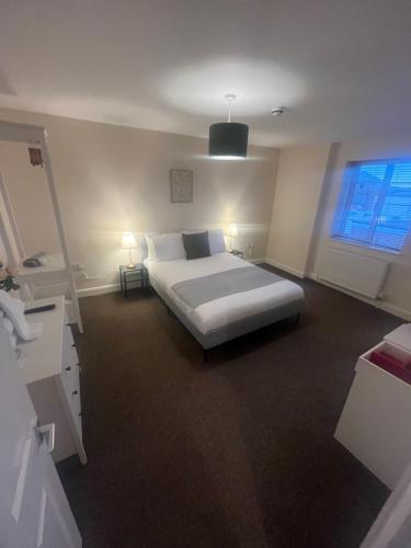 a bedroom with a large bed and a window at Church View Apartment in Great Yarmouth
