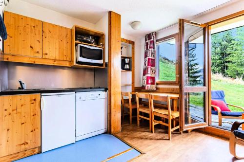 - une cuisine et un coin repas dans une petite maison dans l'établissement Résidence Les Brigues - maeva Home - Appartement 2 Pièces 6 Personnes - Confort MAE-3014, à Courchevel