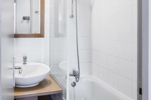 a white bathroom with a sink and a bath tub at Résidence Plagne Lauze - maeva Home - Appartement 2 pièces 5 personnes - S 984 in Mâcot La Plagne