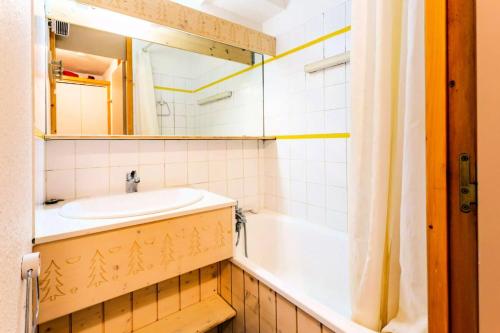 een badkamer met een wastafel, een bad en een spiegel bij Résidence Les Brigues - maeva Home - Appartement 2 Pièces 6 Personnes - Co 014 in Courchevel
