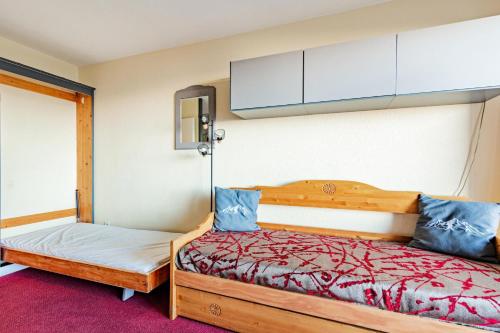 - une chambre avec 2 lits dotés d'oreillers bleus dans l'établissement Résidences quartier Charmettoger - maeva Home - Appartement 2 pièces 5 personnes - Sélection MAE-6324, à Arc 1800