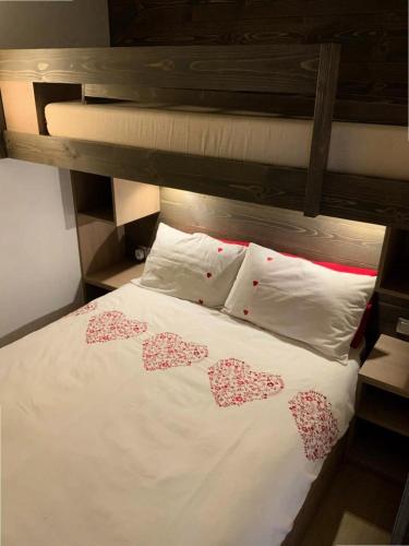 - un lit blanc avec trois cœurs dans l'établissement Résidence Valeriane - La Valériane 4 - Studio proche de la rue piétonne et piste de luge MAE-8144, à Valmorel