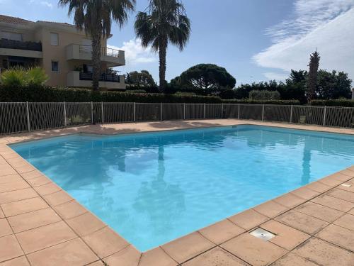 une grande piscine bleue devant un immeuble dans l'établissement Appartement, 1 chambre, Piscine, Wifi..., à La Seyne-sur-Mer