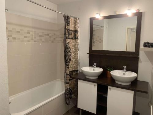 La salle de bains est pourvue de 2 lavabos, d'une baignoire et d'un miroir. dans l'établissement Appartement, 1 chambre, Piscine, Wifi..., à La Seyne-sur-Mer