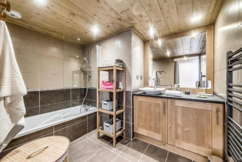 une salle de bain avec une baignoire et un lavabo dans l'établissement Résidence Les Balcons EtoilÉs - Appartement 4 au pied des pistes MAE-3374, à Champagny-en-Vanoise