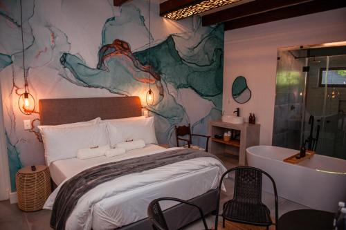 a bedroom with a large bed and a bath tub at Hygge House in Robertson