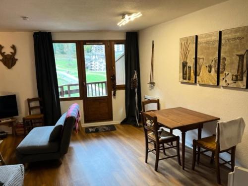 un salon avec une table et une salle à manger dans l'établissement Residence Le Grand Bois - maeva Home - Appartement 2 pièces 4 personnes - Sélection MAE-5824, à La Tania