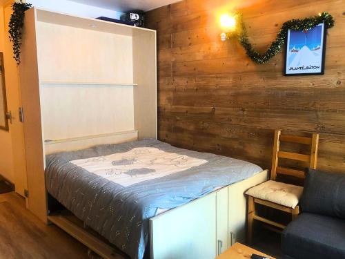 une petite chambre avec un lit et une chaise dans l'établissement Résidence Cheval Blanc - Le Cheval Blanc C27 - Joli studio rénové au pied des pistes MAE-1194, à Valmorel