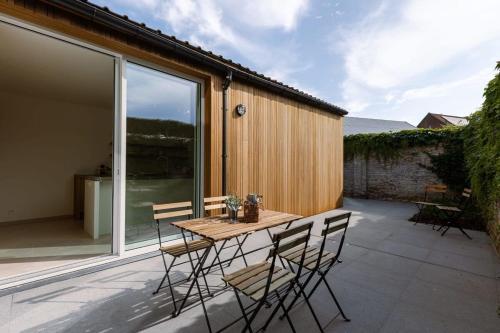 a patio with a wooden table and chairs at Huswell - Beautiful vacation home 'Valkehuisje' in Poperinge in Poperinge