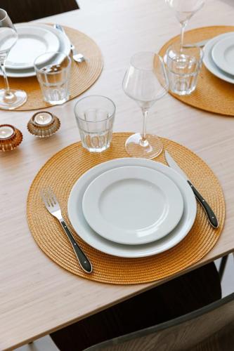 a table with white plates and glasses on a table at Huswell - Beautiful vacation home 'Valkehuisje' in Poperinge in Poperinge