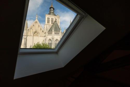 a view of a church through a window at Huswell - Beautiful vacation home 'Valkehuisje' in Poperinge in Poperinge