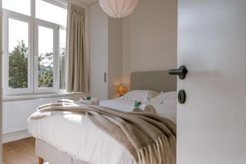 Un dormitorio con una cama blanca con una manta. en Beautiful vacation home 'Valkehuisje' in Poperinge en Poperinge