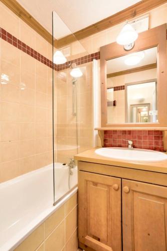 une salle de bain avec un lavabo, une baignoire et un miroir dans l'établissement Quartier La Forêt - maeva Home - Appartement 2 pièces 5 personnes - Sélection MAE-7134, à Valmorel