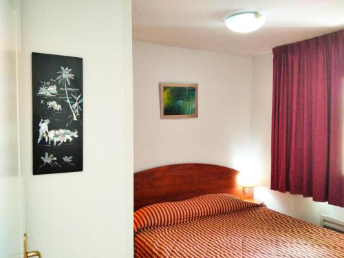 - une chambre avec un lit et un rideau rouge dans l'établissement Résidence Pic Du Midi - 2 Pièces pour 4 Personnes 624, à La Mongie