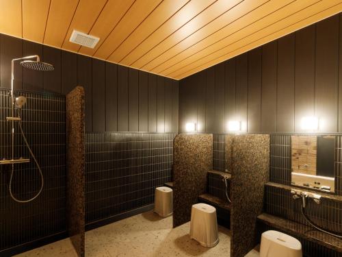 a bathroom with three urinals and a shower at APA Hotel STAY Toyama in Toyama