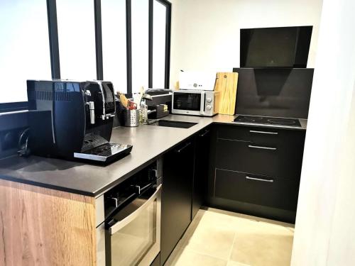 une cuisine avec un comptoir, une cuisinière et un four micro-ondes dans l'établissement Résidence Cotes - Les Côtes 12 - 3 pièces entièrement rénové, proche du centre MAE-4604, à Valmorel