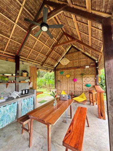 a dining room with a table and a ceiling fan at Triangle Palms Siargao in General Luna