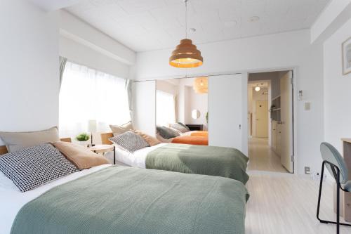 two beds in a room with a bedroom at Kamata Smile House - 蒲田すまいるハウス in Tokyo