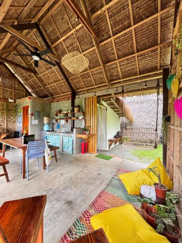 a large living room with a table and a kitchen at Triangle Palms Siargao in General Luna