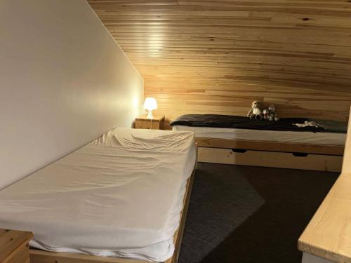 Cette chambre est dotée de 2 lits dans un mur en bois. dans l'établissement Résidence Camarine - La Camarine 19 - Joli 2 pièces avec mezzanine MAE-4614, à Valmorel