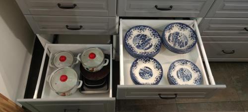 a drawer filled with blue and white plates and bowls at Beach old fisherman's house in Jūrmala