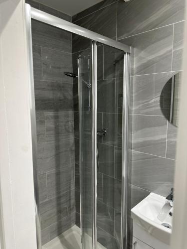 a glass shower in a bathroom with a sink at Guest&rest Ealing 5 in Ealing