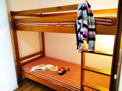 a bunk bed with a book and a toy car at Résidence Pic Du Midi - Studio pour 4 Personnes 774 in La Mongie