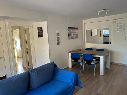 a living room with a blue couch and a table at Edificio Albires in Albir
