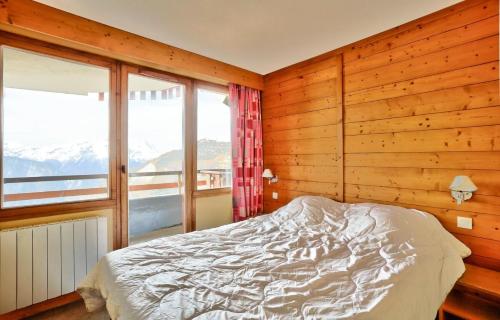 een slaapkamer met een bed en een groot raam bij Résidence L'Ours Blanc - maeva Home - Appartement 3 pièces 7 personnes - C 494 in Huez