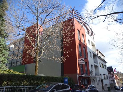 a building on a street with cars parked in front of it at Hotel Rose City in Budapest