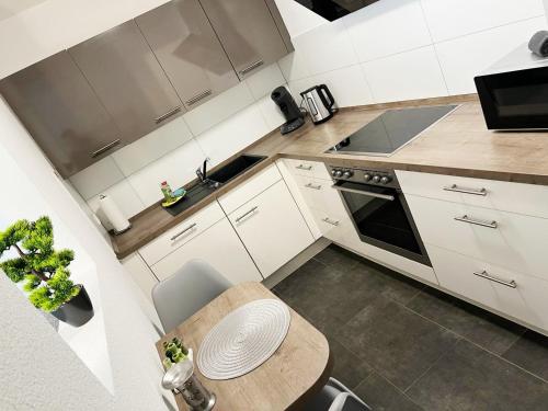 a kitchen with white cabinets and a wooden table at MY HOME N 35 in Villingen-Schwenningen