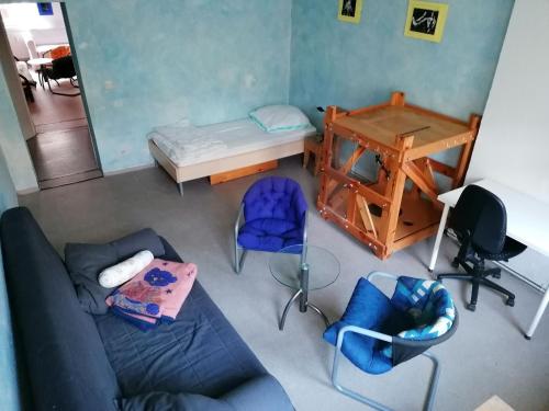 een kamer met een bed, een bureau en stoelen bij Kulturschutzgebiet in Dresden