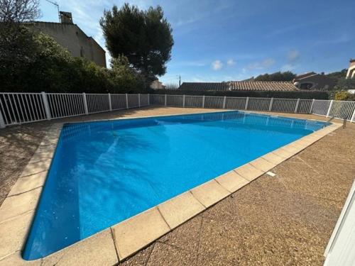 une grande piscine bleue dans une cour dans l'établissement Piscine, plage à pied, 2 chambres, à Six-Fours-les-Plages