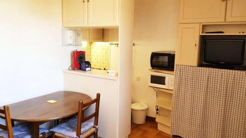 una pequeña cocina con mesa y una pequeña cocina con microondas en Résidence Centre Vars - Studio pour 3 Personnes 914, en Vars