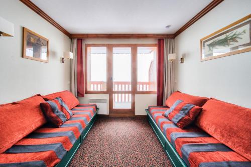 - un salon avec deux canapés rouges et une fenêtre dans l'établissement Résidence La Marelle et Le Rami - maeva Home - Appartement 2 pièces 5 personnes - Sélection MAE-8644, à La Plagne Tarentaise