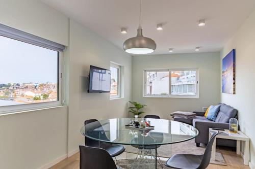 a living room with a glass table and chairs at Lu's Douro View Apartment in Vila Nova de Gaia