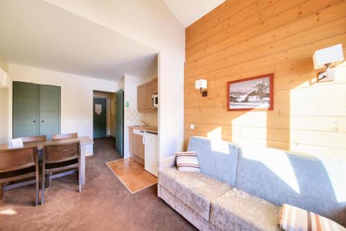 un salon avec un canapé et une salle à manger dans l'établissement Résidence La Marelle et Le Rami - maeva Home - Appartement 2 pièces 4 personnes - Sélection MAE-8624, à La Plagne Tarentaise