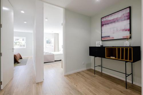 a white room with a piano and a bedroom at Lu's Douro View Apartment in Vila Nova de Gaia
