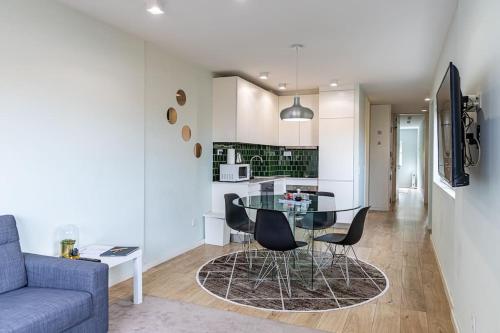 a dining room and kitchen with a glass table and chairs at Lu's Douro View Apartment in Vila Nova de Gaia