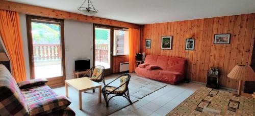 ein Wohnzimmer mit einem roten Sofa und Stühlen in der Unterkunft Résidence Mouflons - 3 Pièces pour 6 Personnes 994 in Vars
