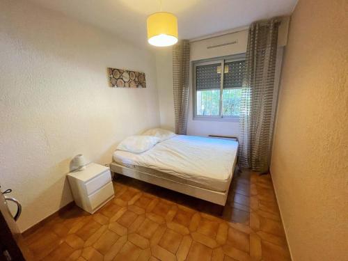 une petite chambre avec un lit et une fenêtre dans l'établissement Bord de plage, rez de jardin,5/7 personnes...WIFI, à Saint-Elme