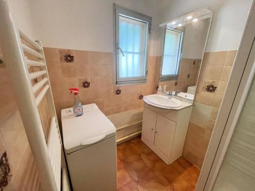 La petite salle de bains est pourvue d'un lavabo et d'un miroir. dans l'établissement Bord de plage, rez de jardin,5/7 personnes...WIFI, à Saint-Elme