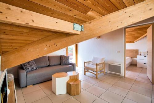 a living room with a couch and a wooden ceiling at Résidence Les Mélèzes - maeva Home - Appartement 2 pièces 4 personnes - 214 in Le Dévoluy
