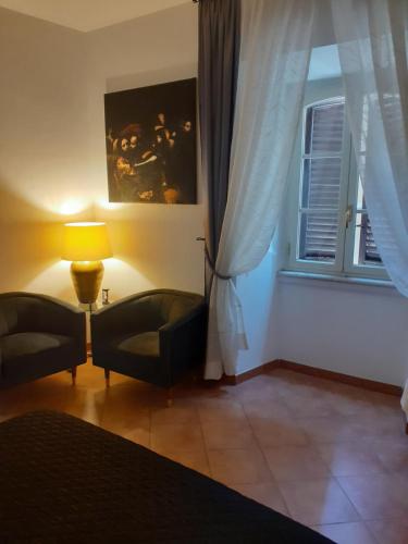 salon z 2 krzesłami i oknem w obiekcie Interno 2 w Rzymie